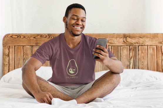 avocado-always-t-shirt-worn-by-a-man-checking-his-phone-while-sitting-in-bed