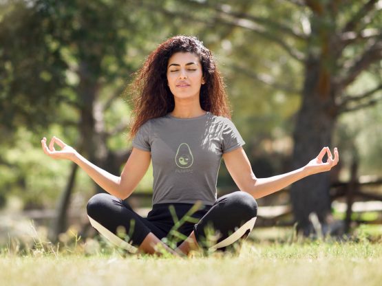 avocado-always-t-shirt-worn-by-a-young-woman-with-curly-hair-meditating-in-the-park