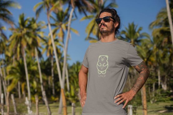 cali-avo-t-shirt-worn-by-a-tattooed-man-standing-by-palm-trees
